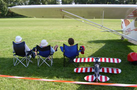 Drei Zuschauer mit Klappst&uuml;hlen